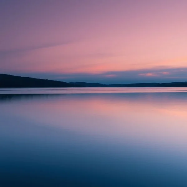 Sinónimos de Sereno (Serene): Un lago pacífico y calmado al anochecer reflejando el cielo