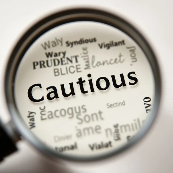 A magnifying glass focusing on the word Cautious, surrounded by synonyms like Wary, Prudent, Vigilant - illustrating Synonyms for Cautious